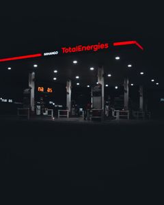 A dimly lit TotalEnergies gas station at night in Nairobi, Kenya, featuring prominent signage.