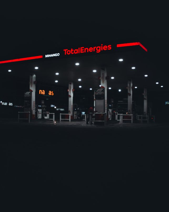 A dimly lit TotalEnergies gas station at night in Nairobi, Kenya, featuring prominent signage.