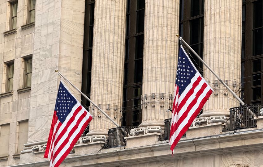 American flags displayed prominently on a historic Wall Street building in New York City.