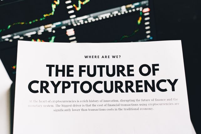 Close-up of a finance article on cryptocurrency with charts in the background.
