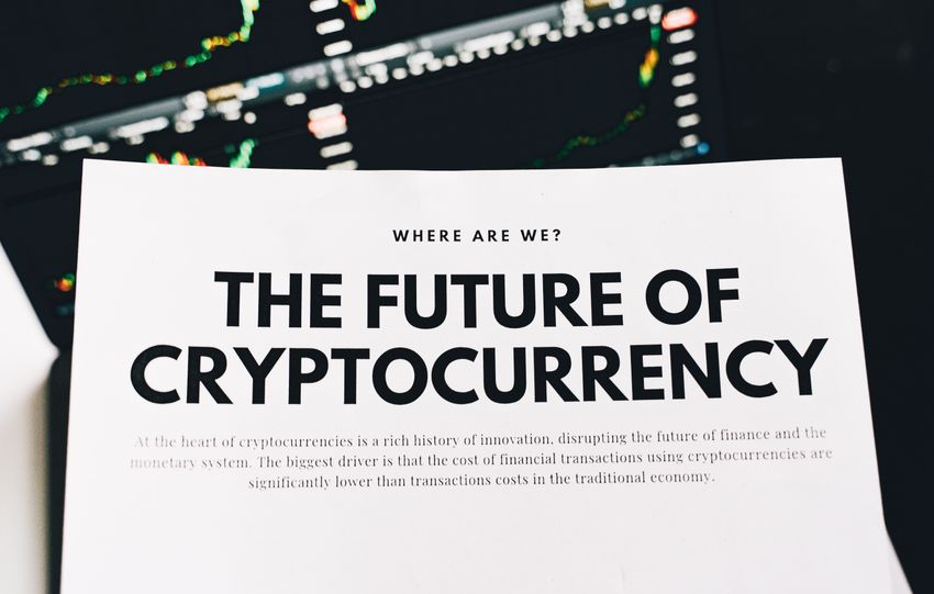 Close-up of a finance article on cryptocurrency with charts in the background.