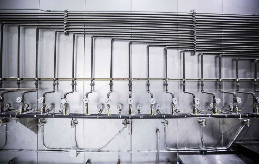 Detailed view of an industrial plumbing system featuring multiple pressure gauges and steel pipes.