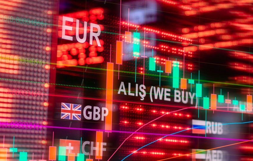 Dynamic forex trading concept with currency symbols and candlestick chart illuminated on screen.