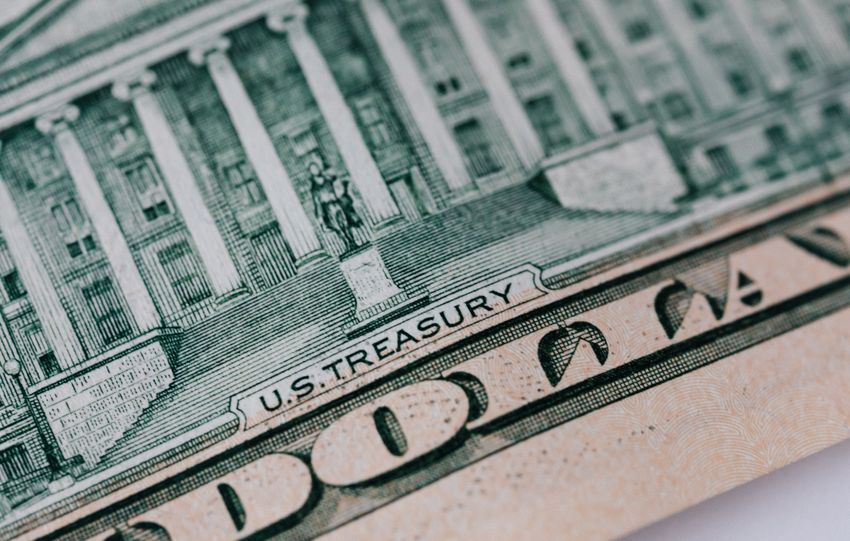From above ten dollar banknote with inscription and United States treasury building placed on table