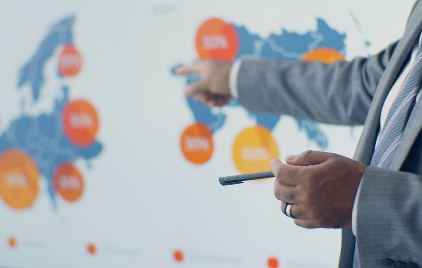 Professional presenting detailed analytics on European map during office meeting.
