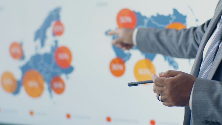 Professional presenting detailed analytics on European map during office meeting.