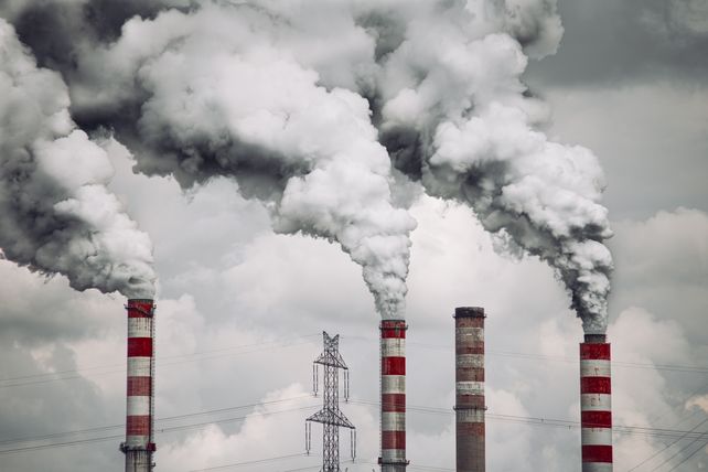 Smoke billows from factory chimneys in Konin, Poland, highlighting pollution and environmental impact.