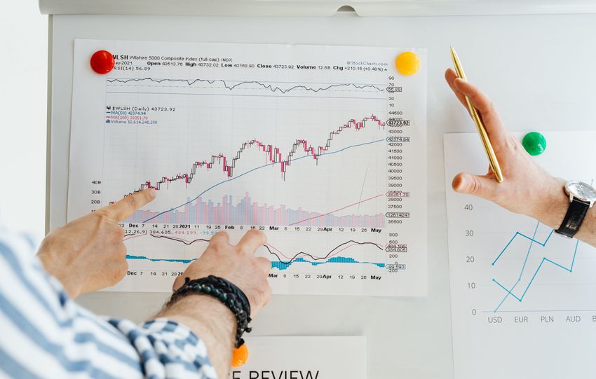 Two professionals analyze stock market graphs with a focus on finance and data trends.