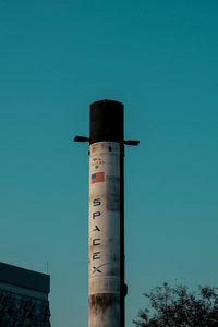 Vertical shot of a SpaceX rocket tower against a blue sky in Dubai, UAE.