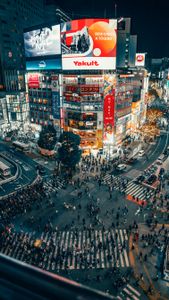 A bustling night scene of Shibuya Crossing, Tokyo, with vibrant city lights and crowds.