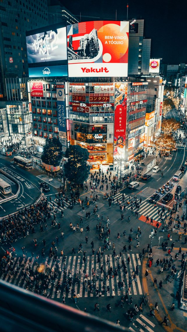 A bustling night scene of Shibuya Crossing, Tokyo, with vibrant city lights and crowds.