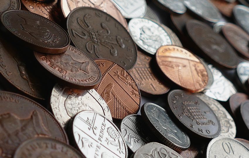 A close-up image of various world coins in a pile, highlighting different currencies.