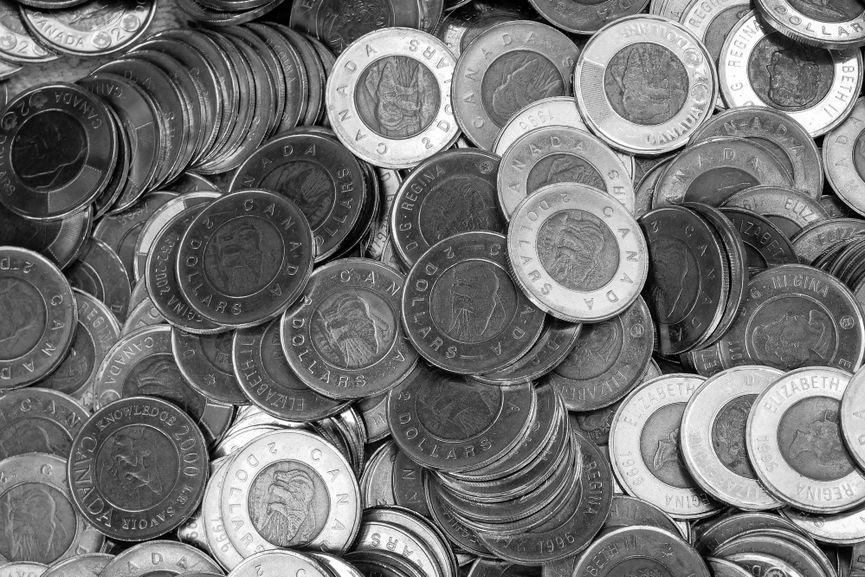 Close-up of Canadian coins in a monochrome color scheme, depicting wealth and currency.