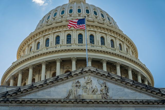 Close-up view of the iconic United States Capitol dome with American flag in Washington, D.C.