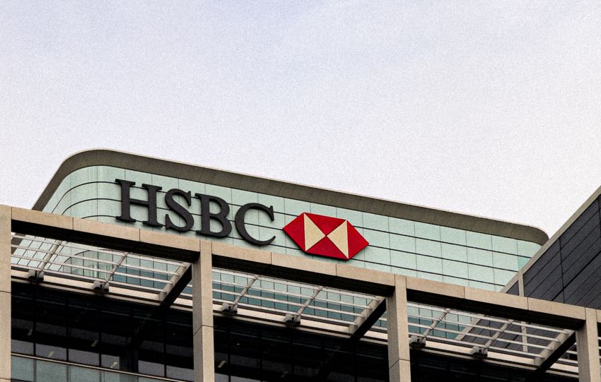 Contemporary architecture of HSBC's headquarters with glass facade under a clear sky.