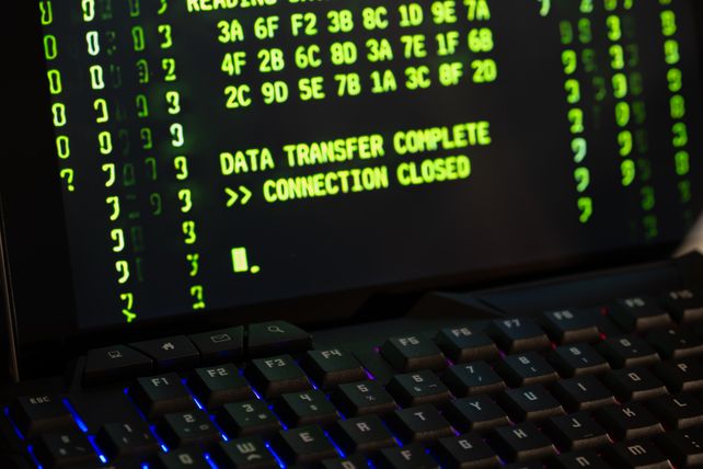 Data transfer complete message displayed on a computer monitor with a keyboard underneath.