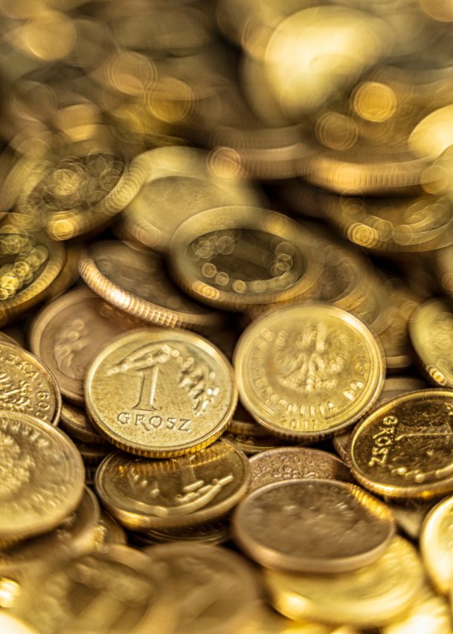 Detailed close-up of Polish grosz coins shining with a golden hue symbolizing wealth and finance.