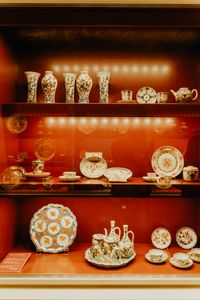 Elegant showcase of vintage porcelain tableware in a Munich gallery.