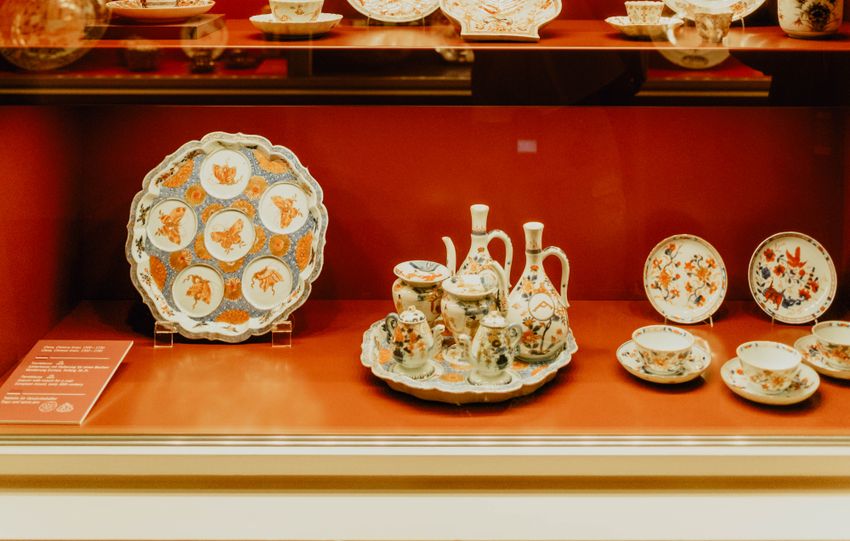 Elegant showcase of vintage porcelain tableware in a Munich gallery.