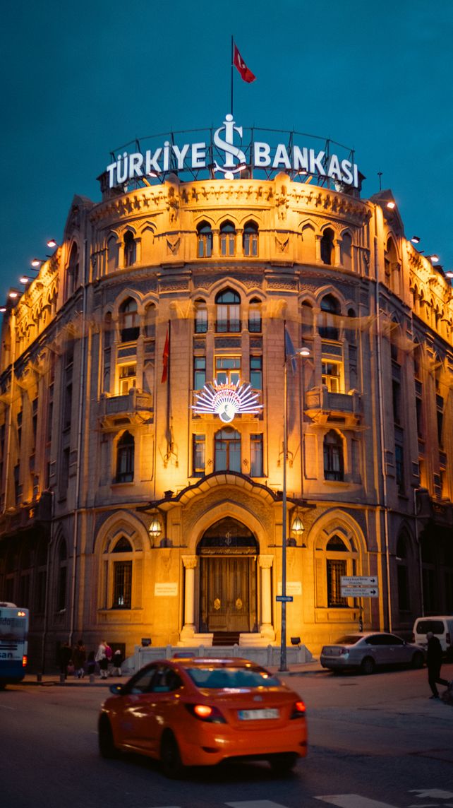 Illuminated Türkiye İş Bankası building in Ankara, Türkiye at night with vehicle motion blur.