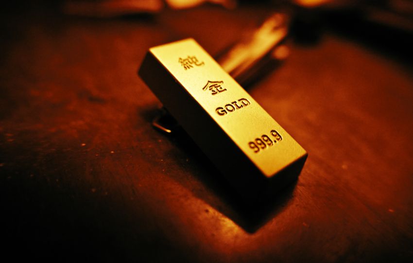 A striking close-up of a gold bar showing inscriptions, captured with warm lighting.