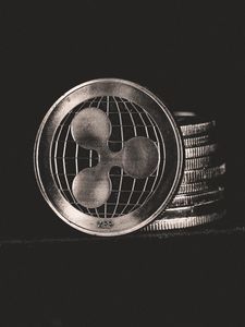 Monochrome image of Ripple coins stacked vertically, symbolizing digital currency.