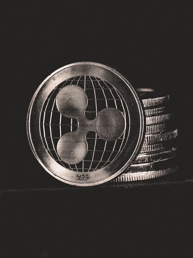 Monochrome image of Ripple coins stacked vertically, symbolizing digital currency.