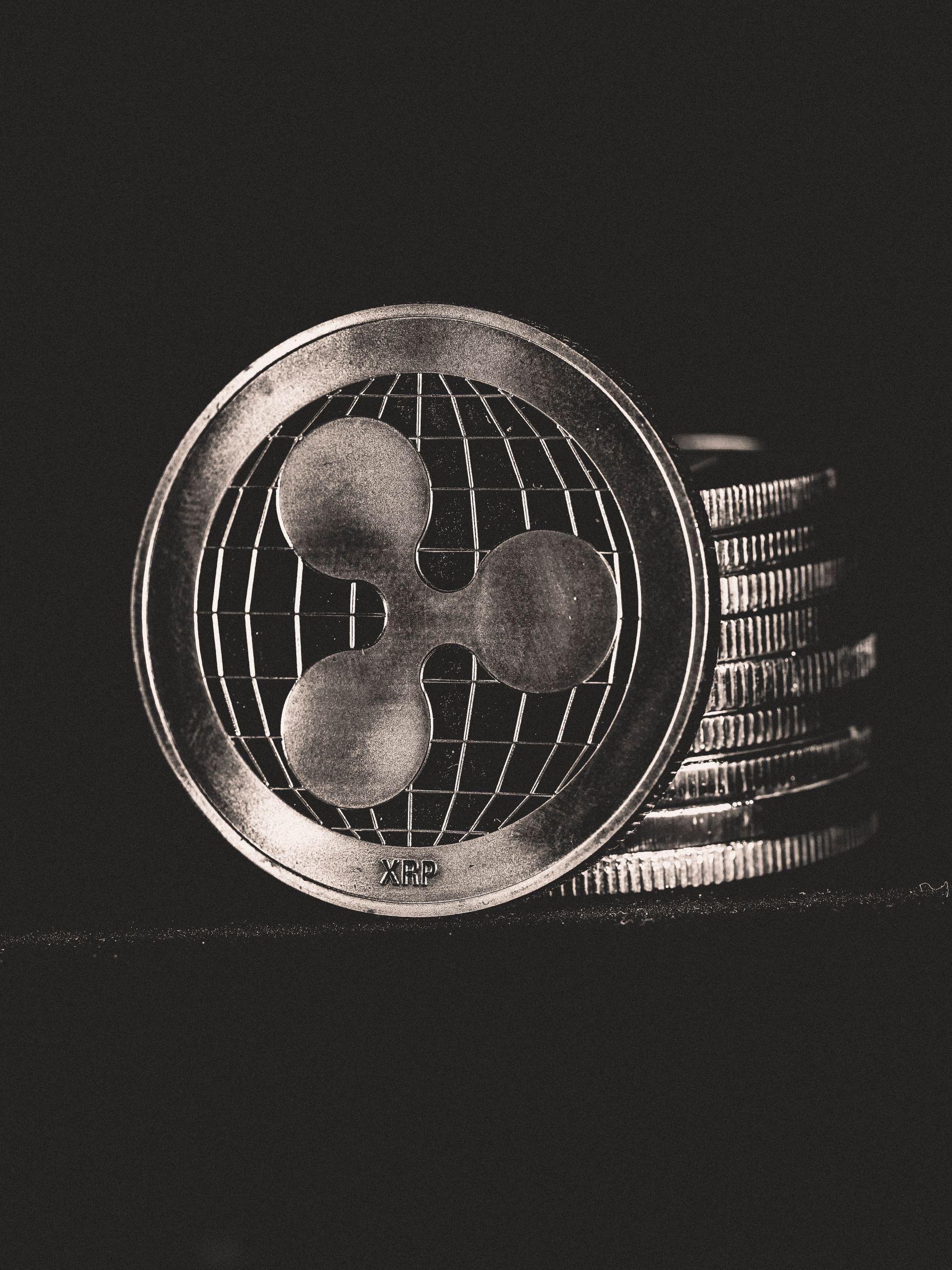 Monochrome image of Ripple coins stacked vertically, symbolizing digital currency.