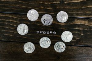 Silver cryptocurrency coins arranged on a wooden surface spelling 'crypto'.