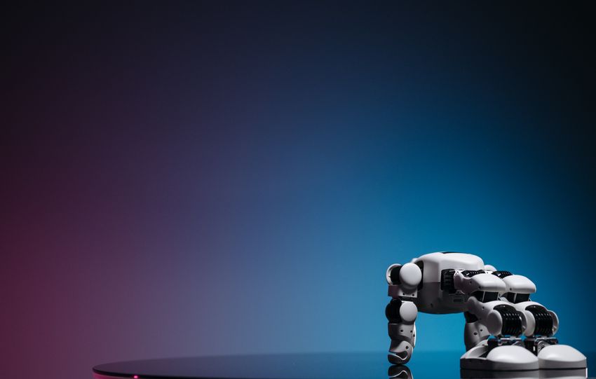 A close-up of a futuristic robot toy on a reflective surface against a gradient background.