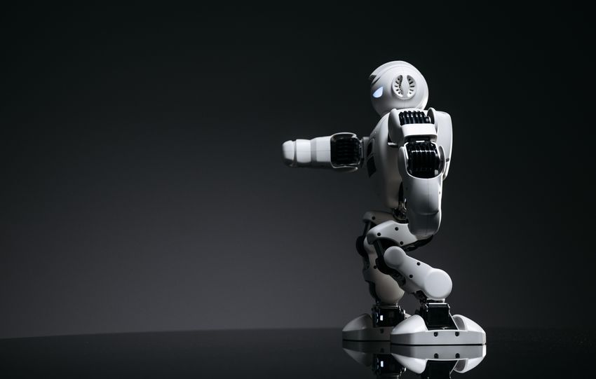 A white robot showcasing modern design on a sleek dark surface.