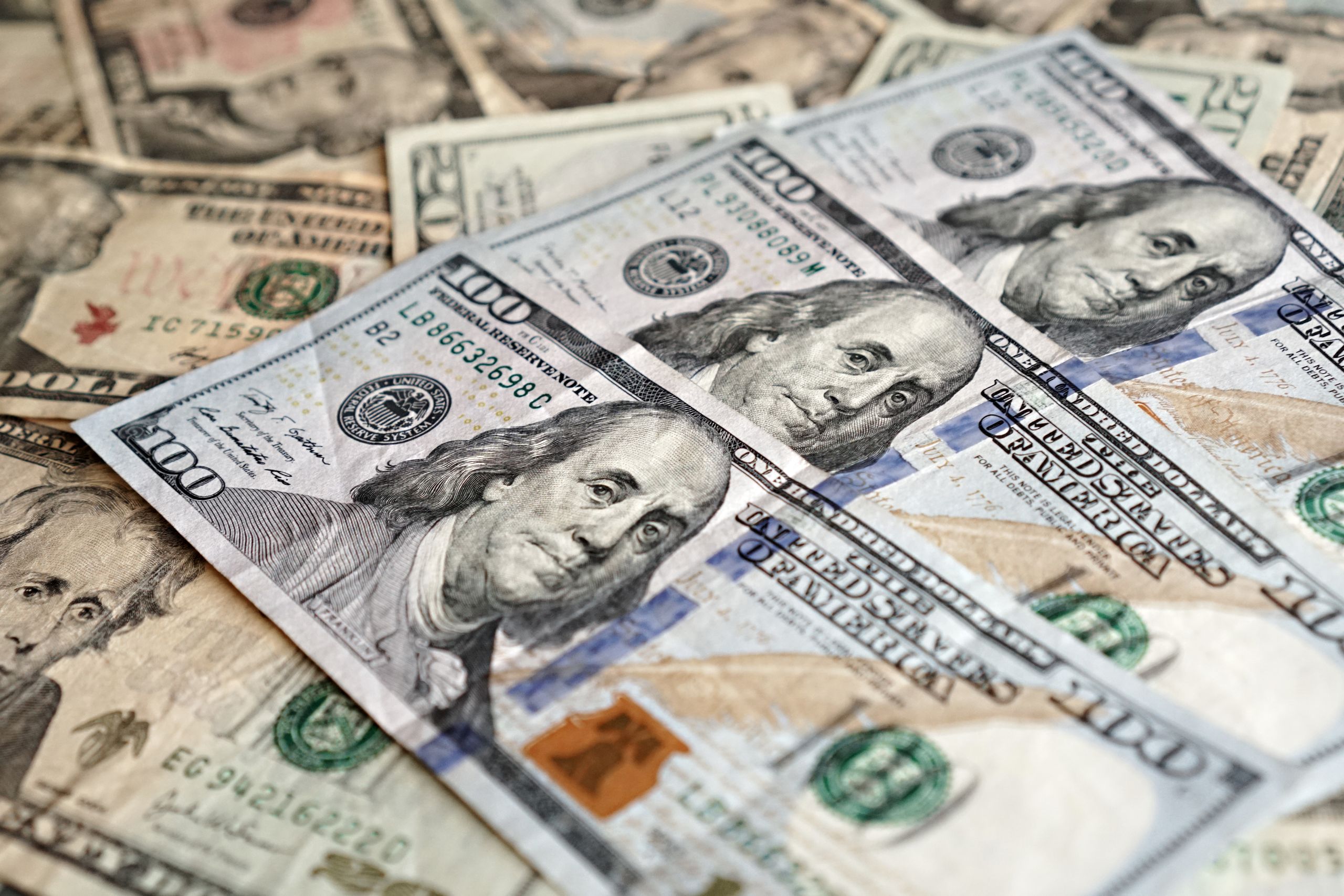 Close-up view of US currency highlighting hundred dollar bills, representing finance and economics.