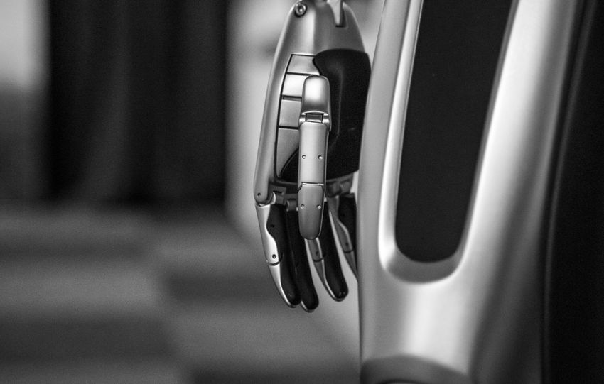 Detailed black and white shot of a futuristic metallic robot arm, showcasing advanced technology.