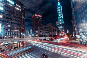 Dynamic night view of Taipei cityscape featuring light trails and the iconic Taipei 101.