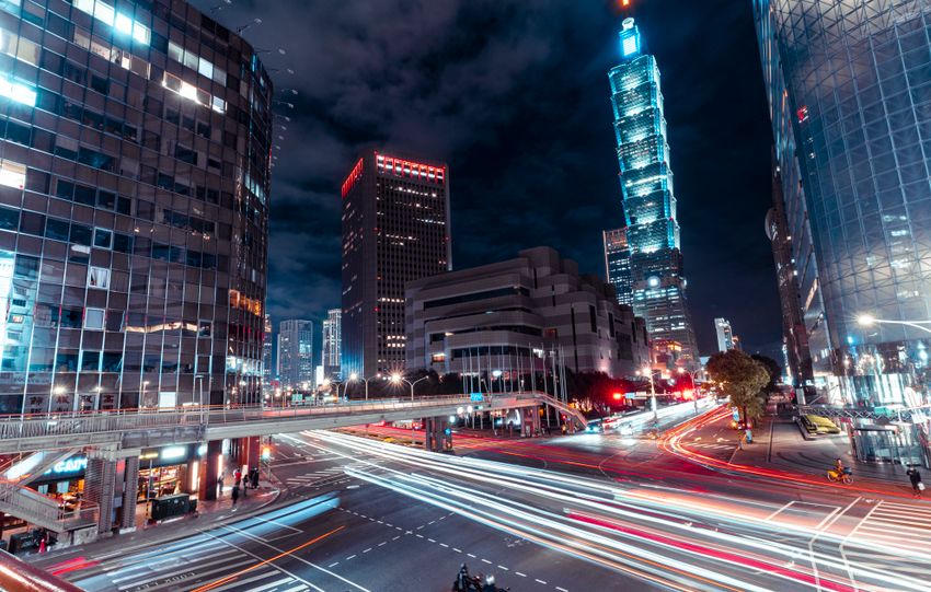 Dynamic night view of Taipei cityscape featuring light trails and the iconic Taipei 101.