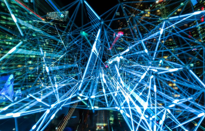 Dynamic urban scene showcasing interconnected light trails representing digital communication networks.