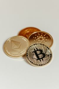 Elegant display of Bitcoin, Ethereum, and Cardano coins on a neutral background.