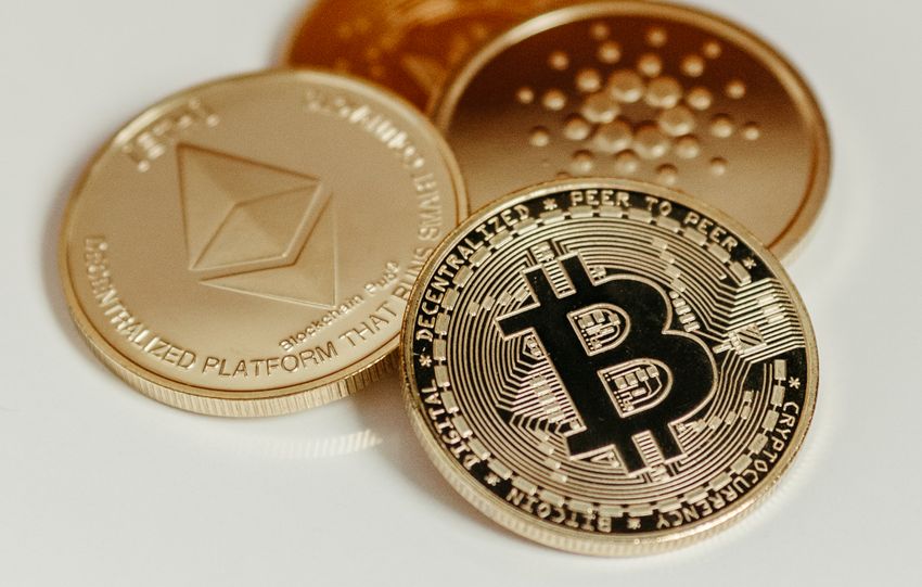 Elegant display of Bitcoin, Ethereum, and Cardano coins on a neutral background.