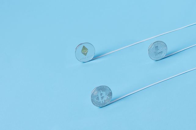 Minimalist image of Bitcoin, Ethereum, and Litecoin coins on a baby blue background.