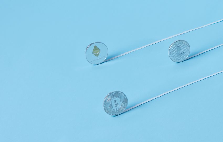 Minimalist image of Bitcoin, Ethereum, and Litecoin coins on a baby blue background.