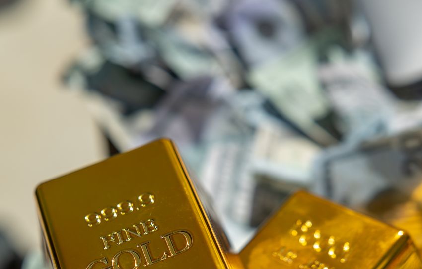 A close-up of shining gold bars on a pile of cash, symbolizing wealth and investment.