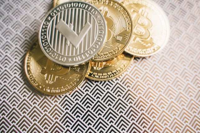 Close-up image of Bitcoin and Litecoin coins on geometric patterned surface.