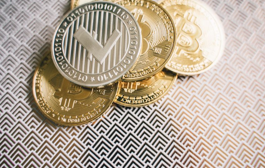 Close-up image of Bitcoin and Litecoin coins on geometric patterned surface.