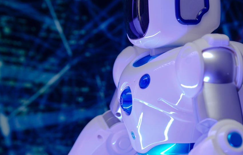 Close-up of a modern humanoid robot with glowing blue lights and futuristic design.