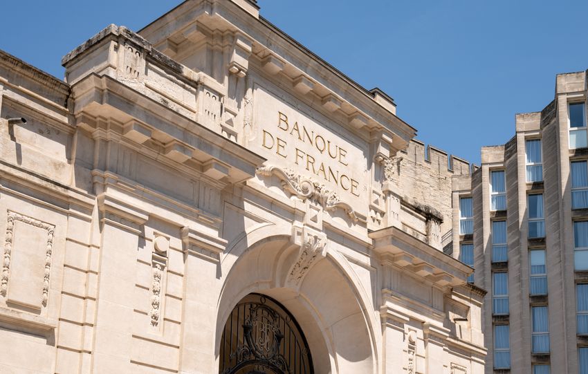 Elegant architectural facade of Banque de France in Avignon against clear blue sky.